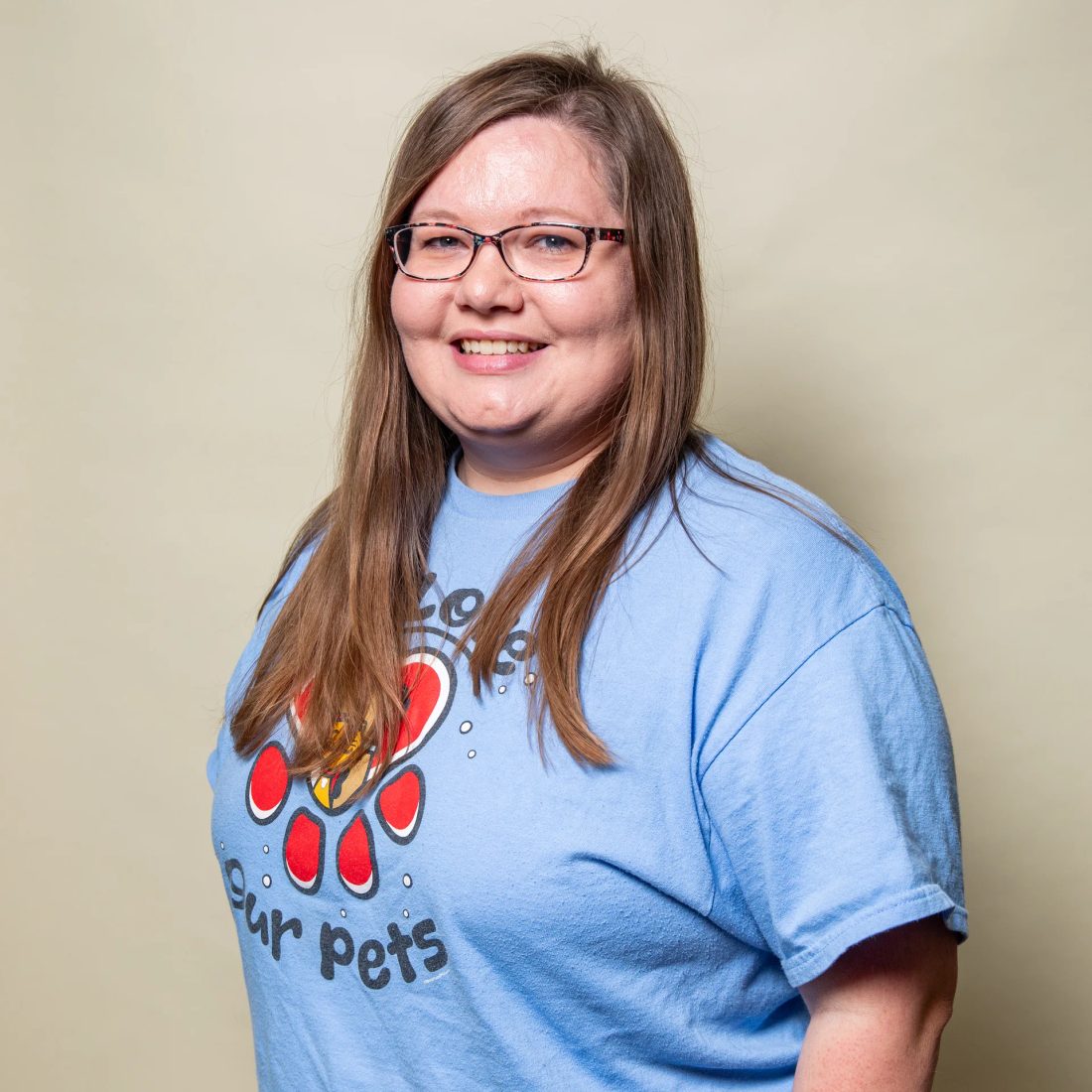 Woman with glasses in blue t-shirt with paw print design
